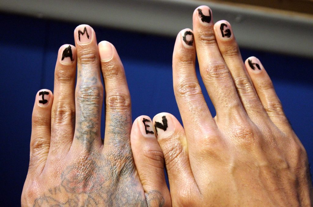 Image of back of two hands in the foreground that have letters written with a thick marker from the left pinky nail all the way to the right pinky nail. There is nothing written in the left index. The letters spell out the word “I am enough.” This was an image used for its powerful message as it helps to drive the point home that we do not need others to give us self-confidence, self-esteem, or self-worth. It is also a message that helps to combat feelings of loneliness and depression.